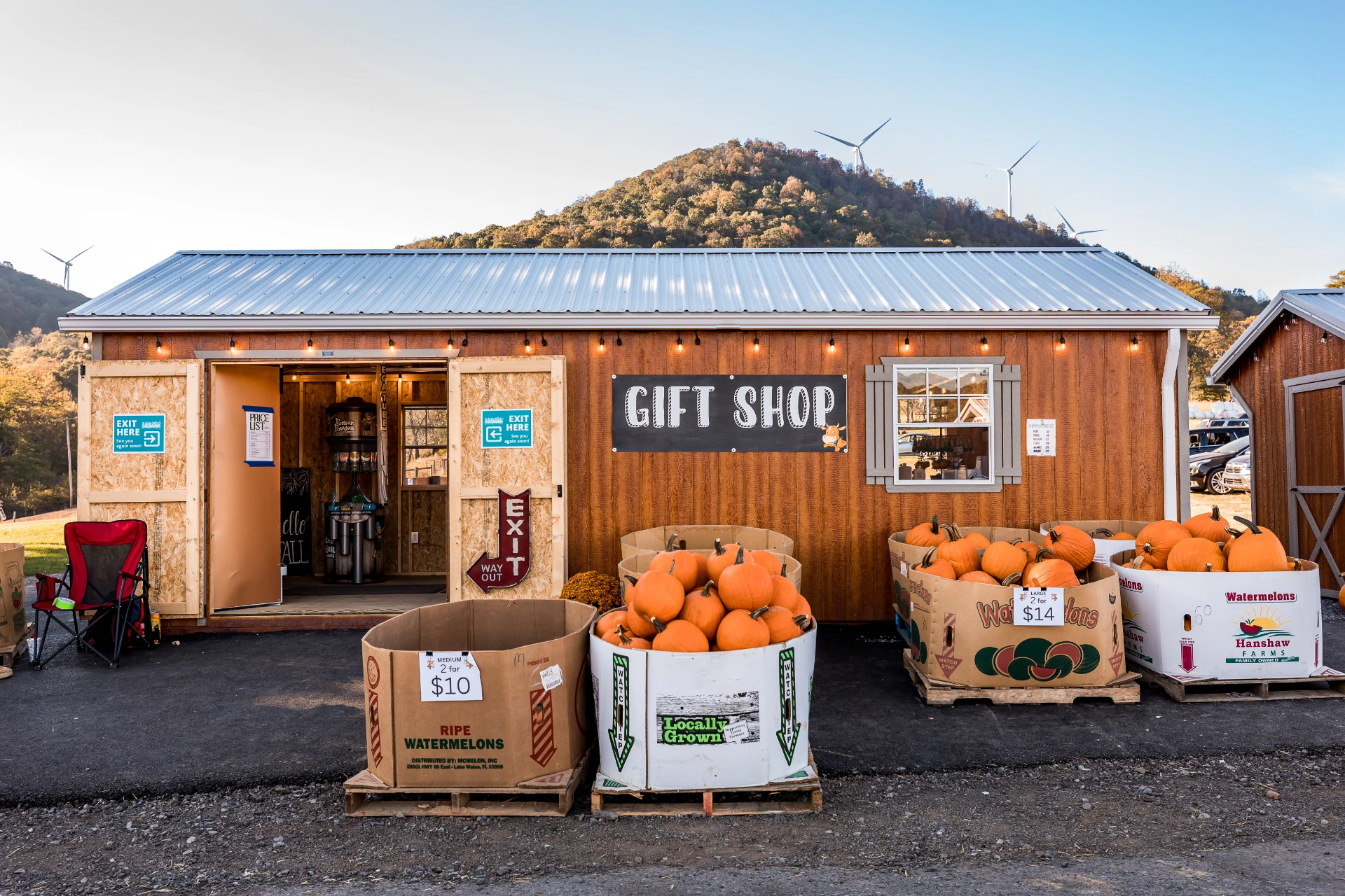 Rustic roadside gift shop with pumpkins and mountain backdrop